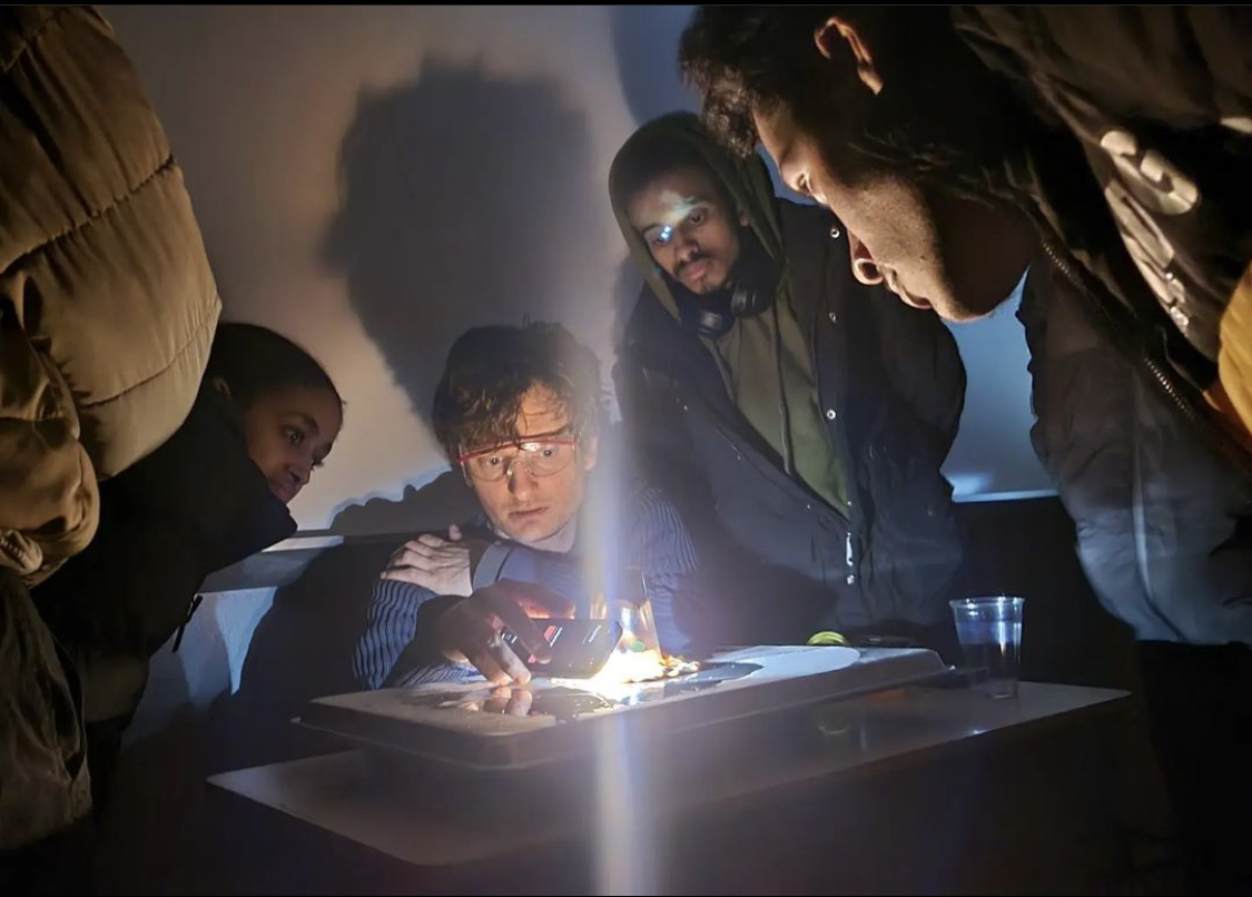 a group of people looking at a lit object