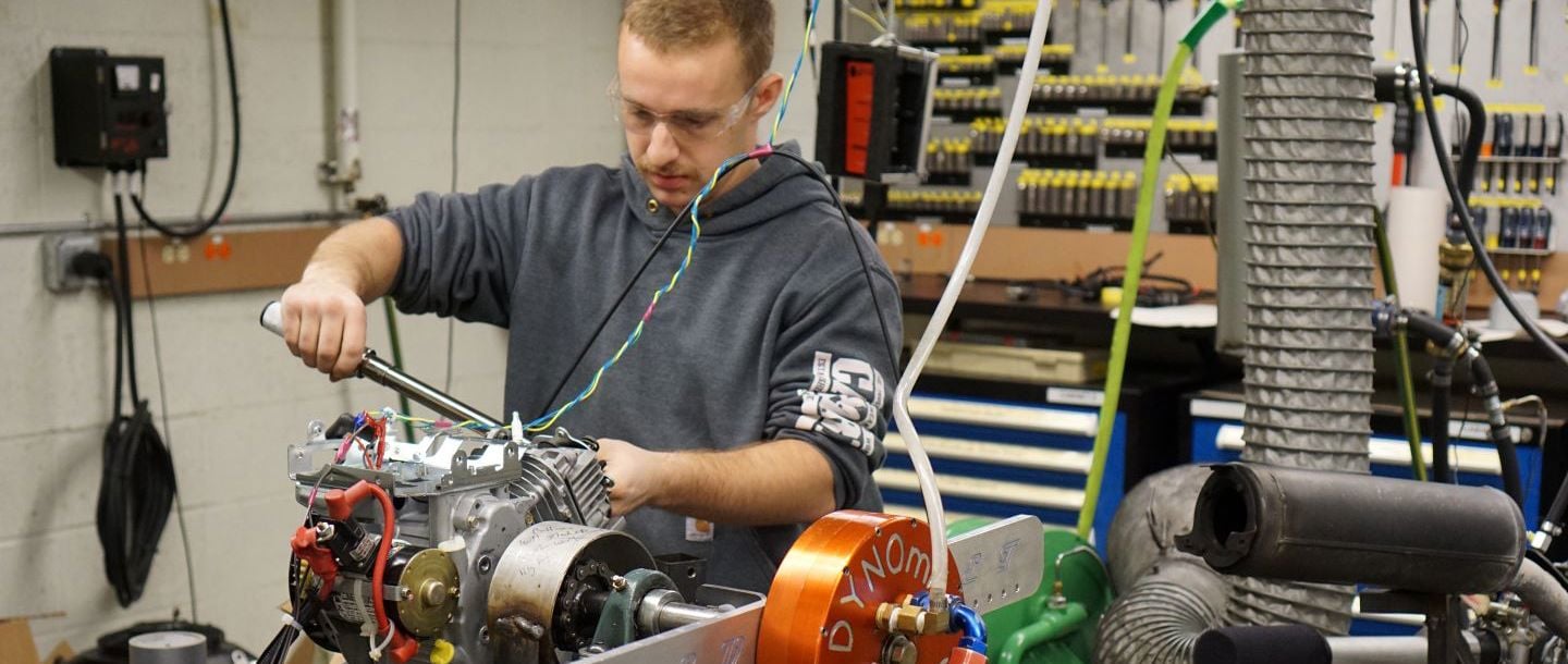 an Automotive Engineering Student working on a car engine