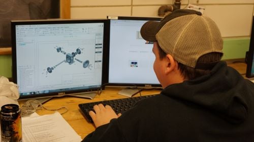 A student using CAD software on a computer in the Automotive and Manufacturing Engineering Technology lab
