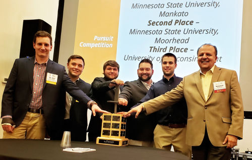 Student team members and professor posing with trophy for taking first place at Pursuit Competition
