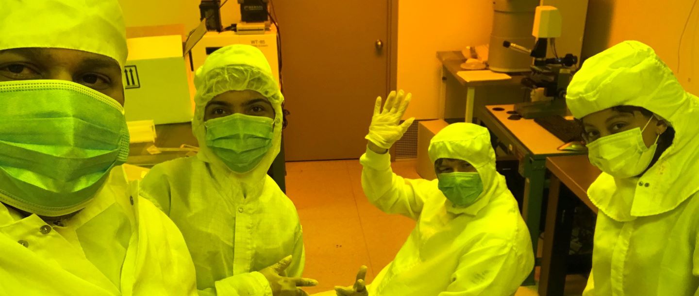 Lab students with their lab instructor in the lab with masks and safety suites on