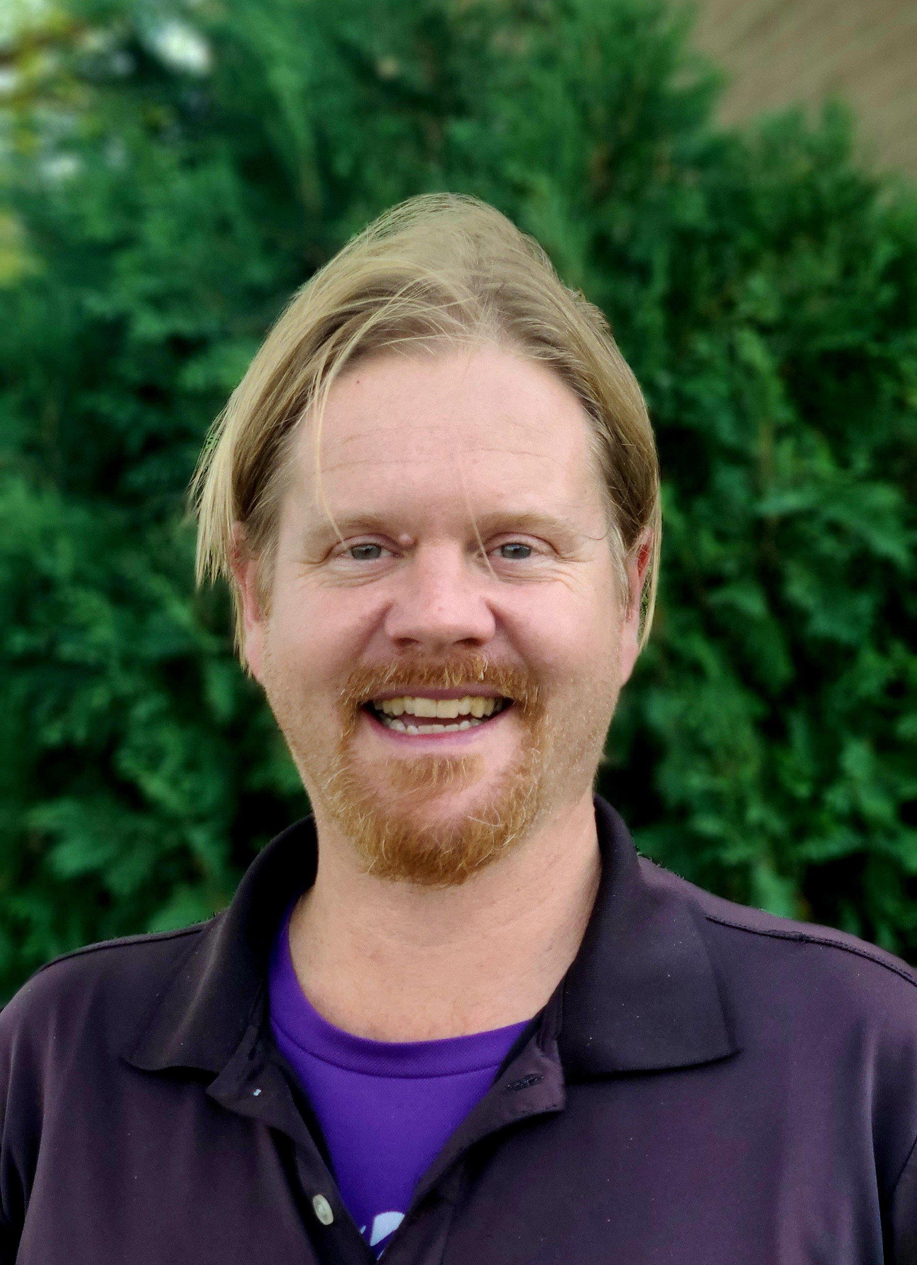 a person with a beard and mustache smiling