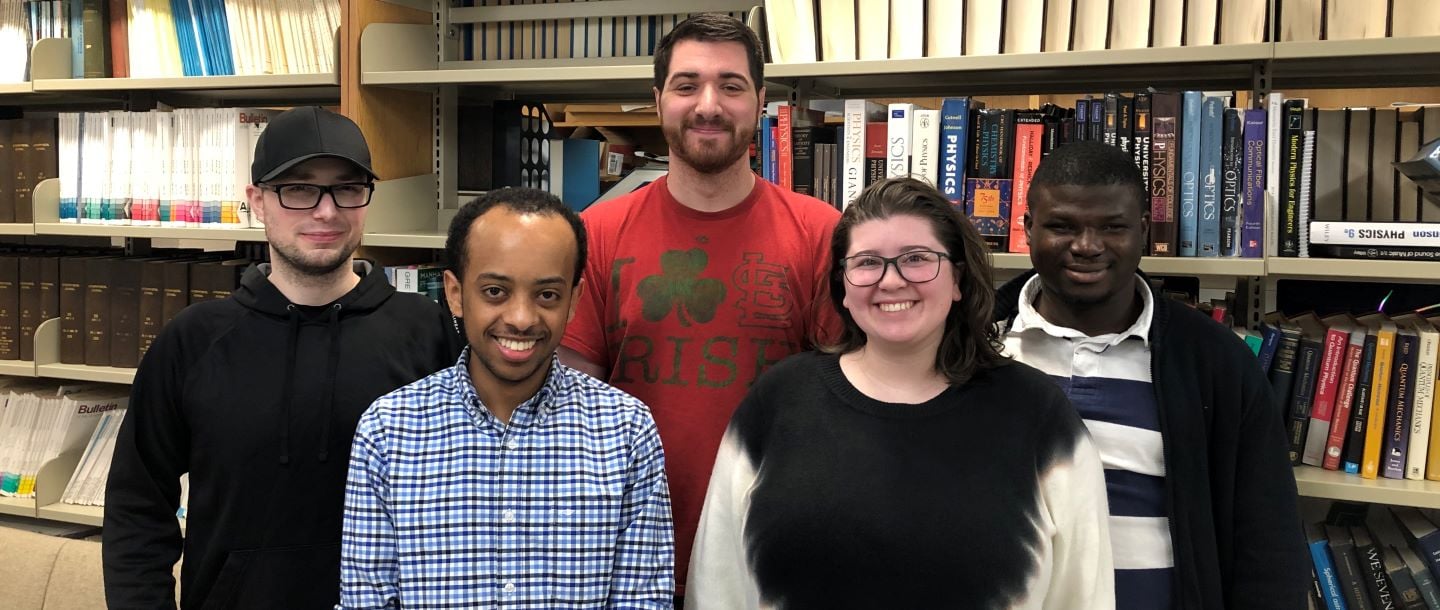 Astronomy and Physics graduate students posing in the library