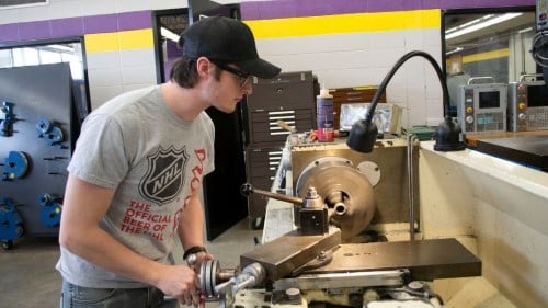 A student working at the a computer numeric controlled (CNC) plasma cutting table in the lab