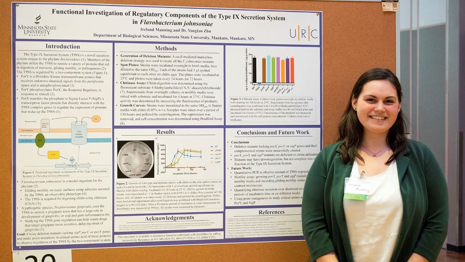 Ireland posing next to her presentation board at the 2022 Undergraduate Research Symposium