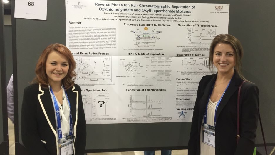 Two students posing next to their research presentation board at the National Conference