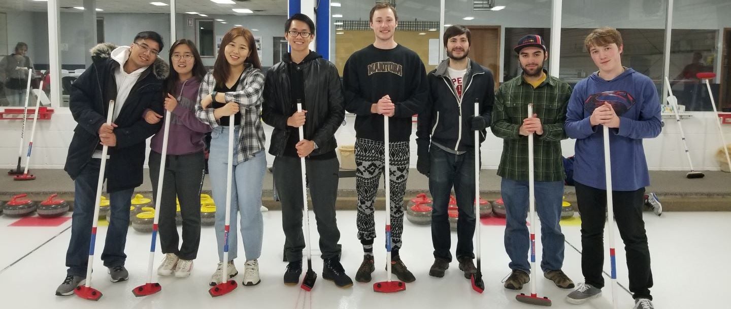 The 2019 ACS curling club members posing inside on the ice