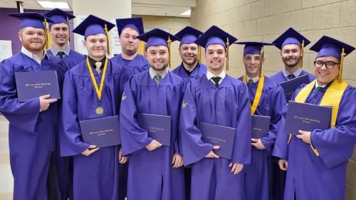 Fall 2019 Construction Management Graduates posing with smiles after the Graduation Ceremony