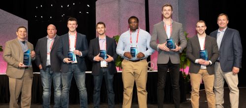 The construction management team of students and professors posing with first place awards at the Roofing Alliance competition