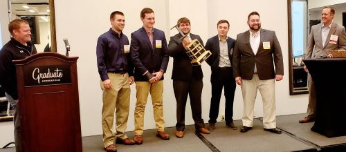 A group of construction management students students posing with trophy at the Pursuit competition