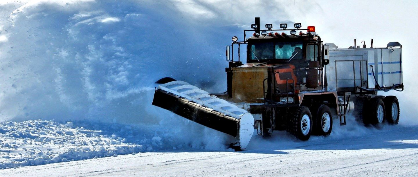 A snowplow clearing snow off the road