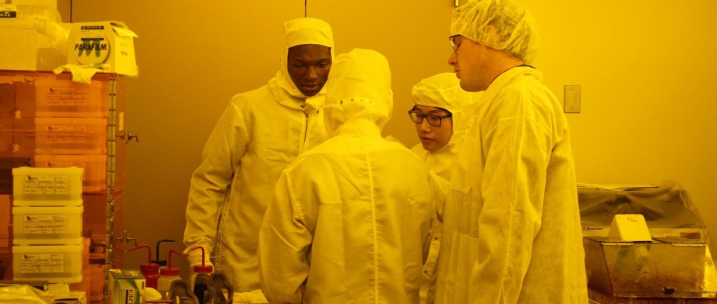 students in the lab wearing lab suits