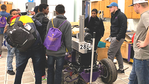 Students in the mechanical engineering lab viewing the designed competitive tractor during the African American Engineering Day