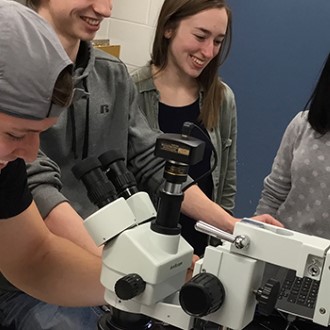 students looking through a microscope in the lab