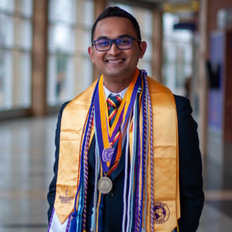 a person wearing a graduation scarf and a medal